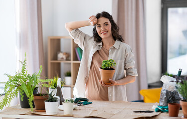 people, gardening and housework concept - tired woman planting pot flowers at home