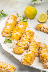 Traditional French dessert eclairs with lemon curd topping. Limoncello italian lemon liqueur,...
