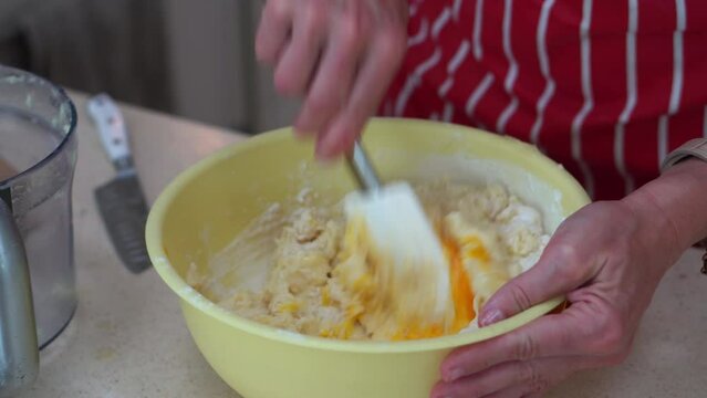 Making Dough For Bryndzove Halusky - Woman Mixing Grated Potatoes, Flour, And Eggs On The Bowl With Spatula. - close up
