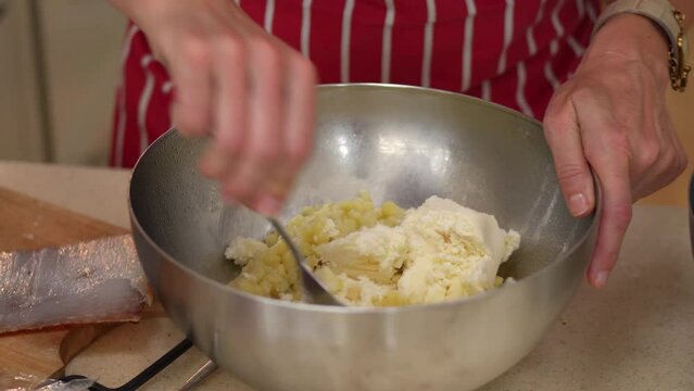 Making Bryndzove Halusky. Mixing Bryndza (Sheep Milk Cheese) Into Halusky (Boiled Lumps Of Potato Dough) In A Bowl. close up