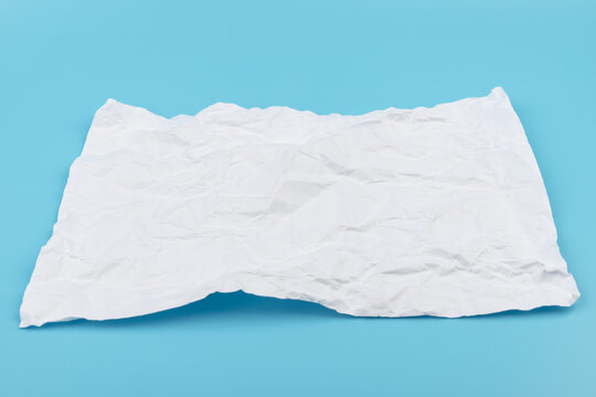 A piece of crumpled white paper on a blue background.
