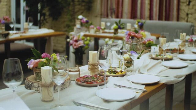 Beautiful wedding decor, all decorated in pink pastel colors, camera moving slow motion. Festive served plates on the table.