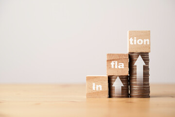Inflation wording print screen on wooden cube block with white up arrow on coins stacking for...
