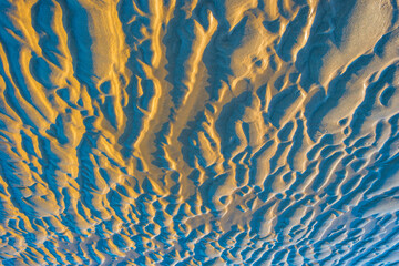 Sand  beach along a sea under a blue sky at a bright sunrise in summer, Walcheren, Zeeland, the Netherlands, July, 2022