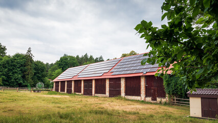 A huge brick barn with solar panels on the roof. Horse stud in Florianka. Beautiful rural landscape