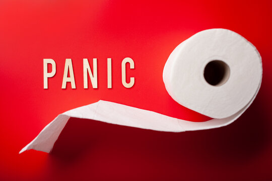 panic word toilet paper text wooden letter on red background