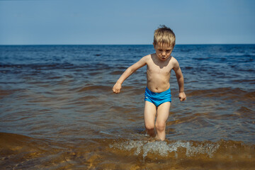 cute little boy getting out from sea