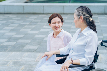 シニア女性に話しかけるエプロン姿の女性