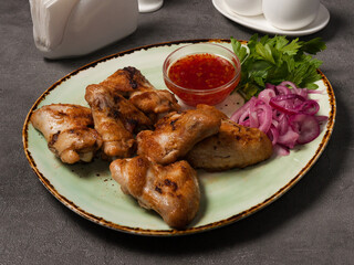 grilled chicken wings with hot sauce, red onion and herbs