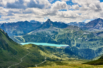 mountain landscape with cloud sky in the silvretta mountain range above cyan colored Barrier Lake Kopsseenear Galtür, Tyrol, Austria - obrazy, fototapety, plakaty