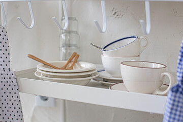 Various kitchen utensils on white shelves