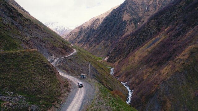 Aerial Drone View Of Black Off-road Car On Dangerous Dirt Road Between In The Mountain Hills. SUV. High Quality Photo