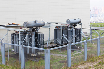 Two high voltage oil-filled power transformers on urban electrical substation. Electrical power...