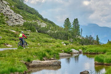 Fototapeta na wymiar nice active senior woman riding her electric mountain bike in the silvretta mountain range near Gaschurn, Tyrol, Austria