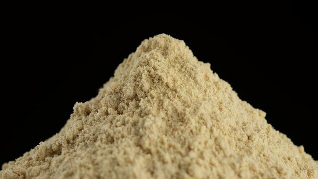 Dry ground ginger isolated on black background, rotation. 4K UHD footage