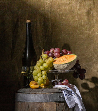 still life of fruit and wine standing on an old wine barrel