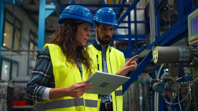 Female chief engineer in modern industrial factory looking at camera, close-up