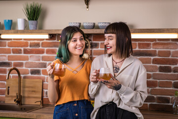 In the morning charismatic beautiful lesbian couple take a hot tea drink and discussing in the country style kitchen concept of LGBT freedom equality friendship