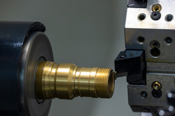 The  CNC lathe machine thread cutting the brass pipe connector parts. - obrazy, fototapety, plakaty