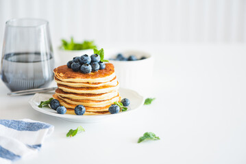 Homemade baked ricotta pancakes with fresh berries on white wooden table