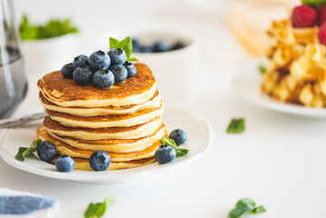 Homemade baked ricotta pancakes with fresh berries on white wooden table