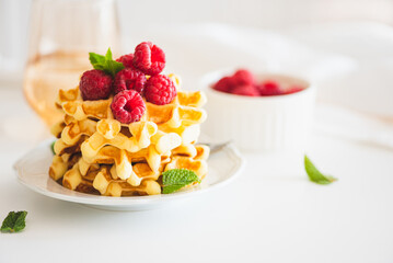 Homemade baked Belgian ricotta waffles with fresh berries on white wooden table