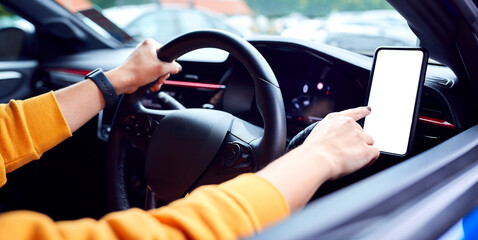 Close Up Of Driver With Hands Free Unit For Mobile Phone Mounted On Dashboard