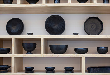 Pottery dishes and cups on wooden shelves