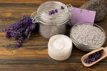 Fototapeta na wymiar Lavender spa. Sea salt, body scrub, lavender flowers and handmade soap. Natural herbal cosmetics with lavender flowers on brown texture wood.Spa and relaxation concept.Beauty treatments.Copy space.