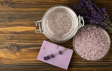 Obraz na płótnie Canvas Lavender spa. Sea salt, lavender flowers and handmade soap. Natural herbal cosmetics with lavender flowers on brown texture wood.Spa and relaxation concept.Beauty treatments.Copy space.