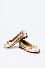 Gold women boat shoes pair isolated on light grey background.