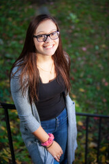 Obraz premium portrait of a pretty teenaged girl with dark hair and glasses in park