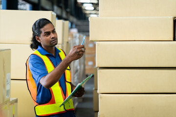 A man in charge of a large warehouse is checking the number of items in the warehouse that he is responsible for.