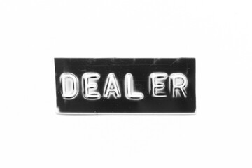 Black color banner that have embossed letter with word dealer on white paper background