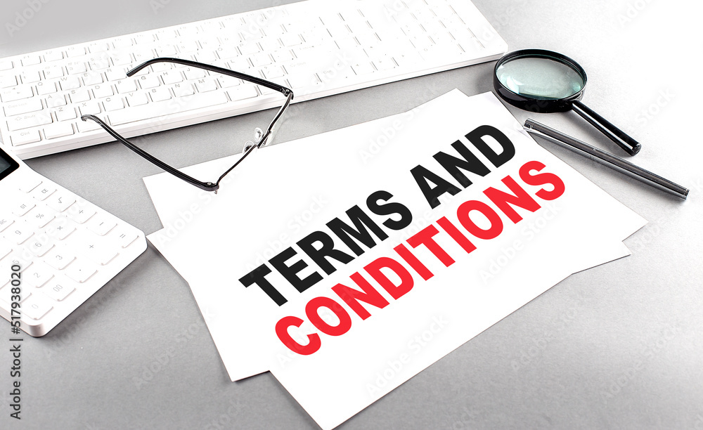 Poster terms and conditions text on a paper with keyboard, calculator on grey background