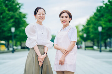 エプロン姿の女性と私服の女性
