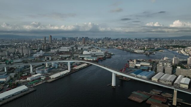 Slow pullback on bridge over river and sprawling city at sea level