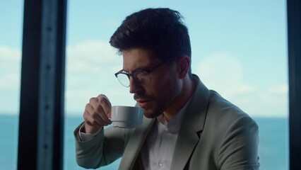 Serious business man drink coffee in ocean view office. Man lifestyle concept - Powered by Adobe