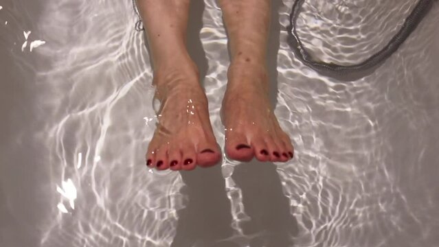 woman feet painting red on feet nail in bath tub