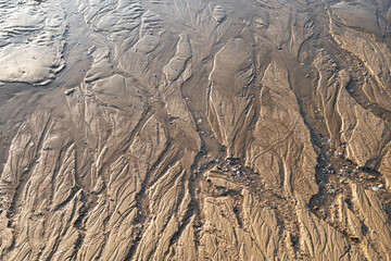 Patterns on sandy beach after low tide on the ocean.abstract sand nature background. Close up of patterns on the sand surface from sea water after low tide in the island