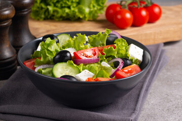 Greek salad with fresh tomatoes, cucumber, olives, feta cheese and red onion. Healthy and diet food concept.