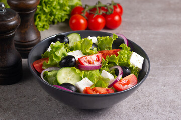 Greek salad with fresh tomatoes, cucumber, olives, feta cheese and red onion. Healthy and diet food concept.