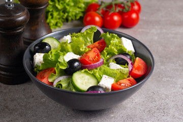 Greek salad with fresh tomatoes, cucumber, olives, feta cheese and red onion. Healthy and diet food concept.