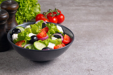 Greek salad with fresh tomatoes, cucumber, olives, feta cheese and red onion. Healthy and diet food concept.