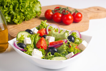 Greek salad with fresh tomatoes, cucumber, olives, feta cheese and red onion. Healthy and diet food concept.
