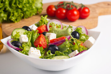 Greek salad with fresh tomatoes, cucumber, olives, feta cheese and red onion. Healthy and diet food concept.
