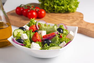 Greek salad with fresh tomatoes, cucumber, olives, feta cheese and red onion. Healthy and diet food concept.