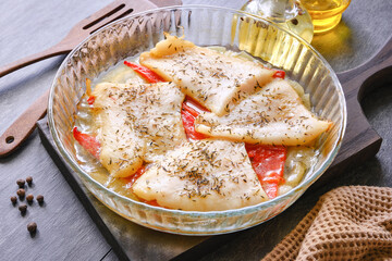 Fish cooked in the oven. Baked cod fish served in bowl. Cooking fish in the oven. Cooking fish with peppers and herbs in the oven. Selective focus.