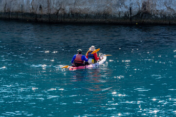 Unidentified sporters in kayak is Calanque de Port-Miou near Cassis, excursion to Calanques national park in Provence, France