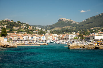 Naklejka na ściany i meble Panoramic view on cliffs, blue sea, beach, houses, streets and old fisherman's harbour with lighthouse in Cassis, Provence, France